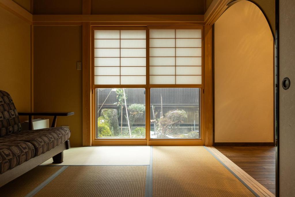 a room with a large window and a couch at Arai アライ in Takayama