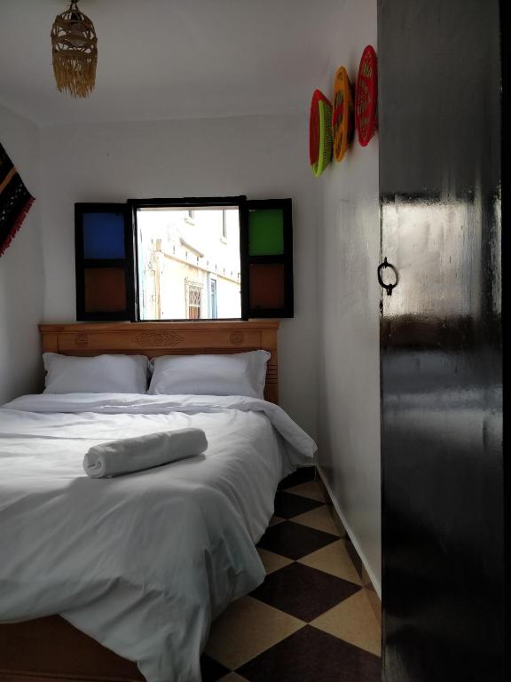 a bedroom with a bed with two towels on it at Taghazout Beachside Haven Ocean View Apartment in Taghazout