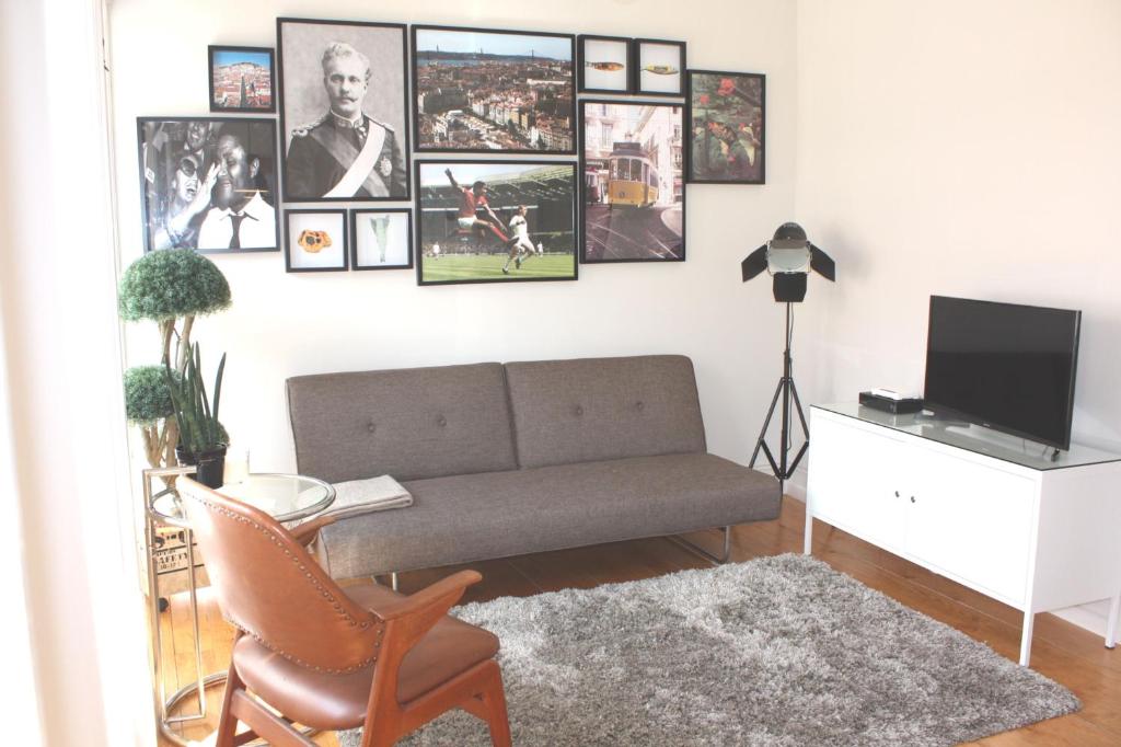 een woonkamer met een bank en foto's aan de muur bij Baixa Charming Apt. | Cascão 18 in Lissabon