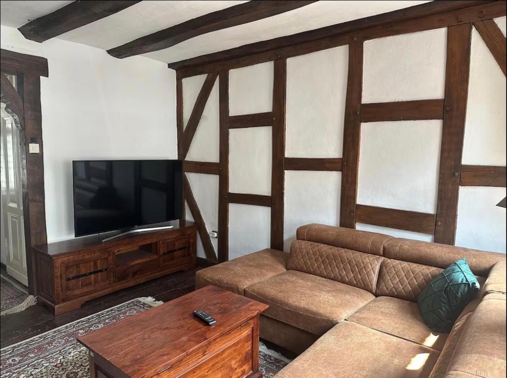a living room with a couch and a flat screen tv at Stadthaus 34 - Check-in 24h in Kevelaer