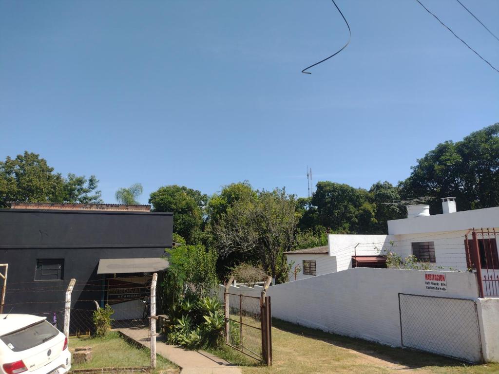 a white house with a fence and a white car at Habitacion - Tercio in São Gabriel