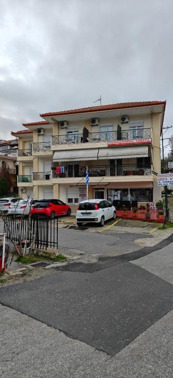 a parking lot with cars parked in front of a building at Skordas Comfy Rent Rooms in Thessaloniki