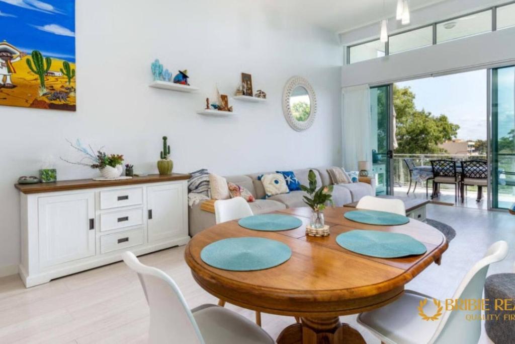 a living room with a wooden table and white chairs at Sapphire Heaven in Woorim