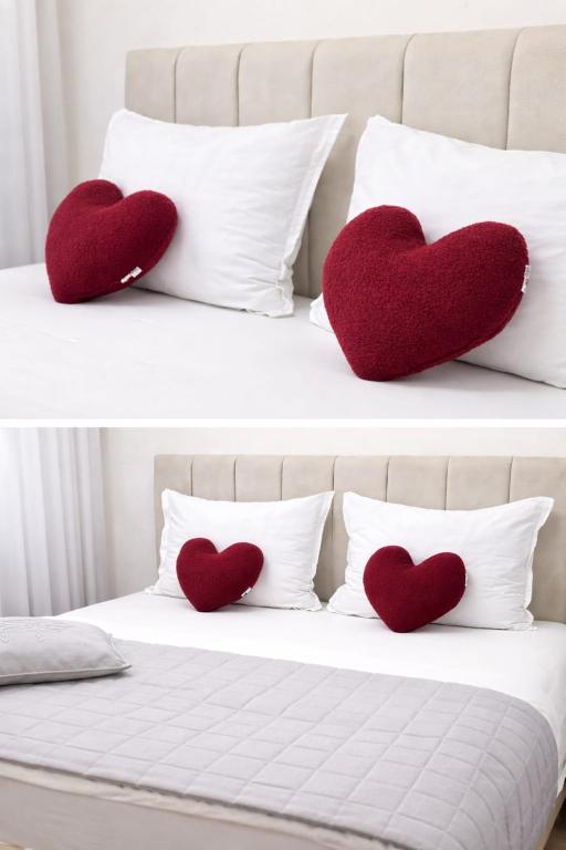 two red hearts on a bed with white pillows at Sara Luxe Apartment in Konjic