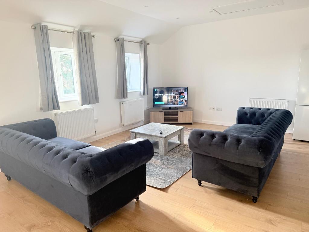 a living room with two couches and a tv at Pear Barn Haven in Wisbech Saint Mary