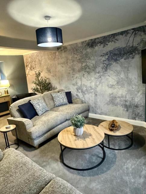 a living room with a couch and two tables at BROOMBANK, Melrose in Gattonside