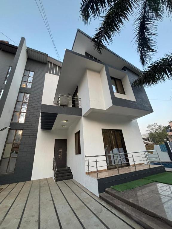 a large white house with a balcony in front of it at Shalimar Villa-2 in Jāmb
