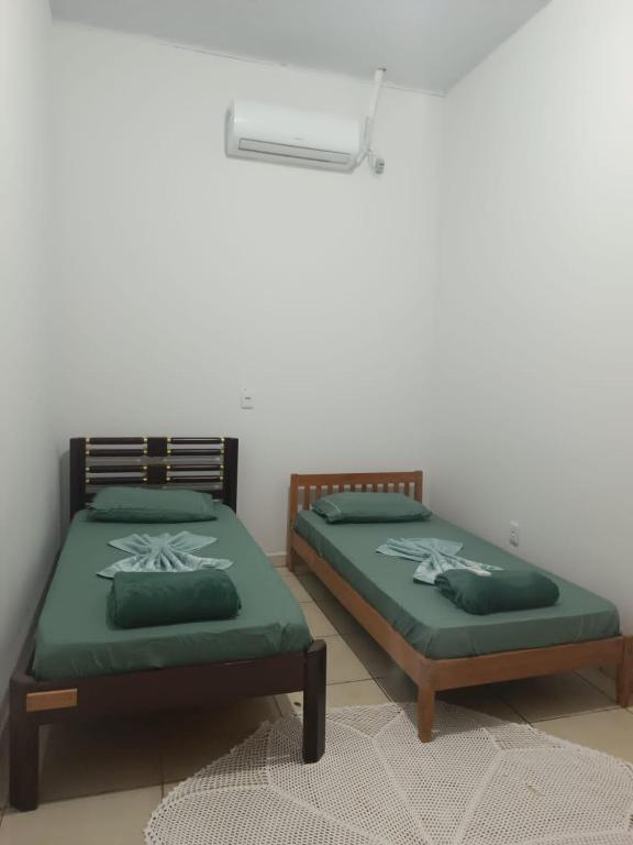 two beds sitting next to each other in a room at Casa perto da Unemat in Cáceres