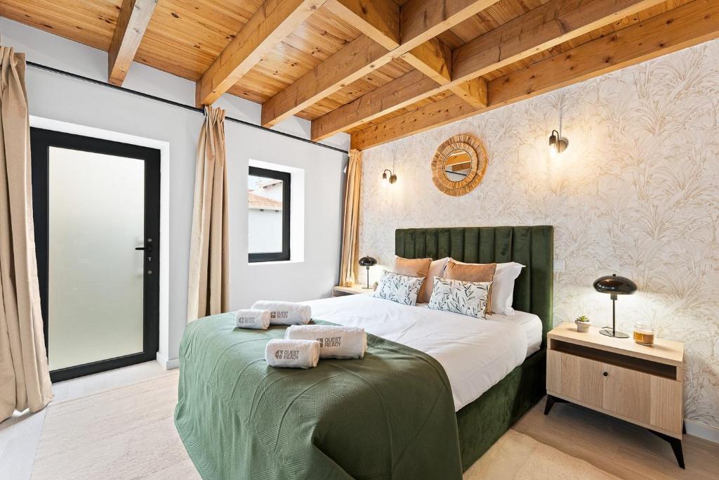 a bedroom with a large bed with towels on it at GuestReady - Charming cosy home in Porto