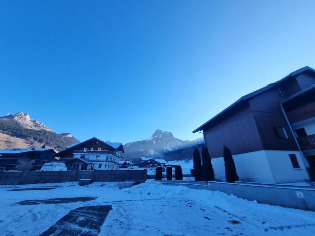a village in the snow with mountains in the background at Cœur des neiges in Bernex
