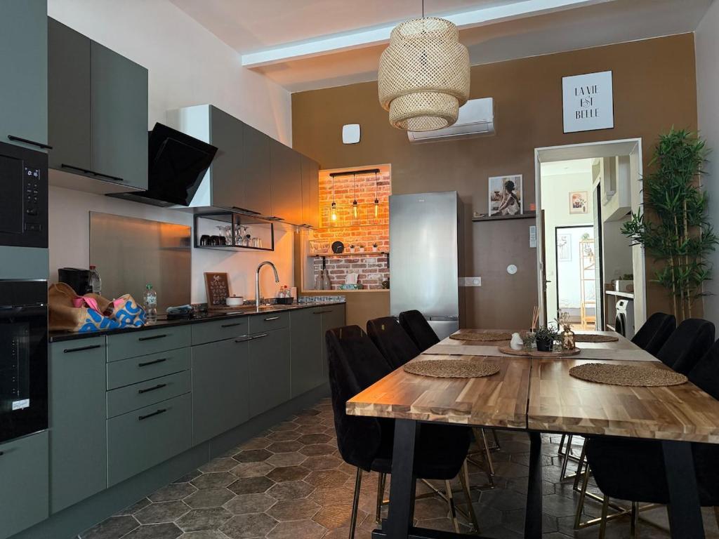 a kitchen and dining room with a table and chairs at La Vie Est Belle climatisé à 5 min de la plage in Dunkerque