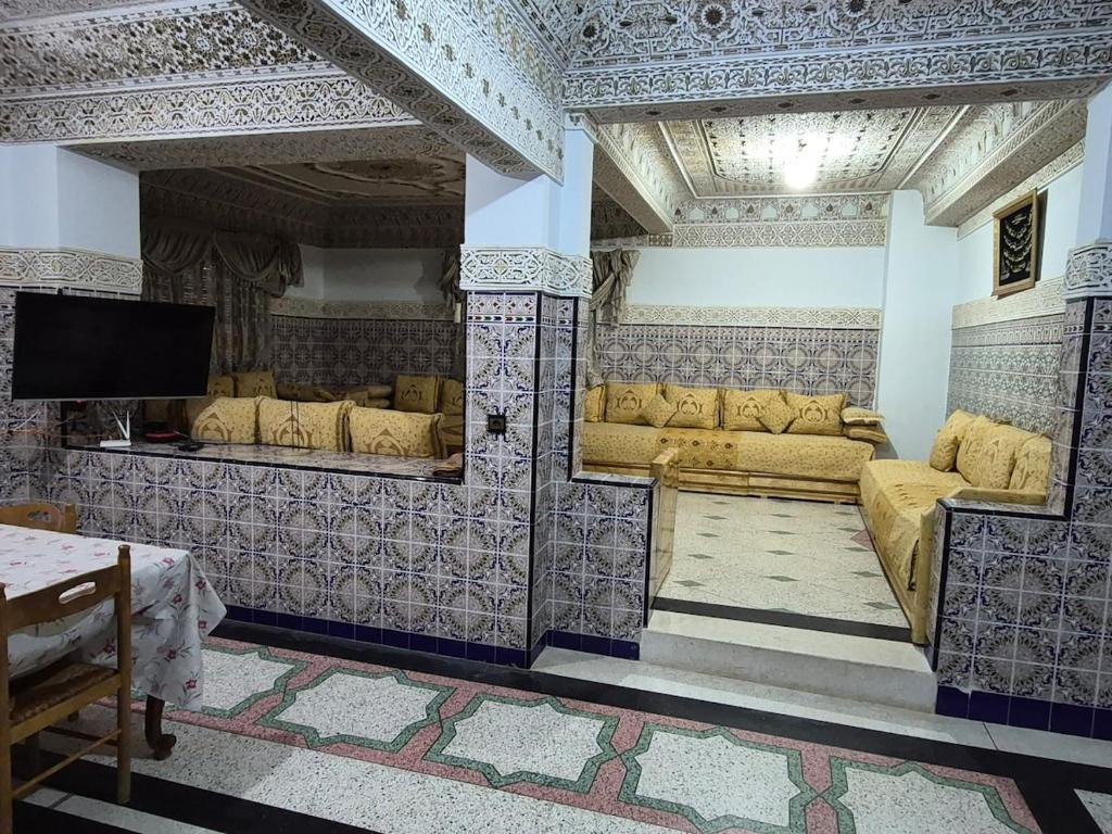 a living room with couches and a flat screen tv at Appartement familial villa 110 m2 jardin et piscine in Meknès