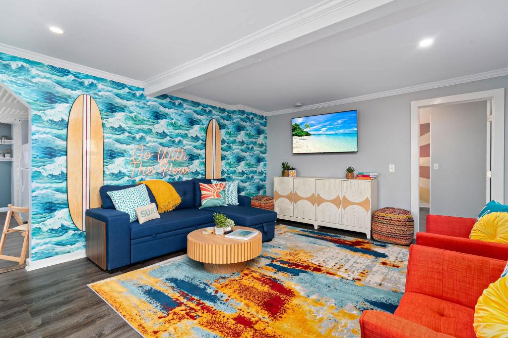 a living room with a blue couch and surfboard mural at Salisbury Surf Pet Friendly 1 Block to Beach in Salisbury