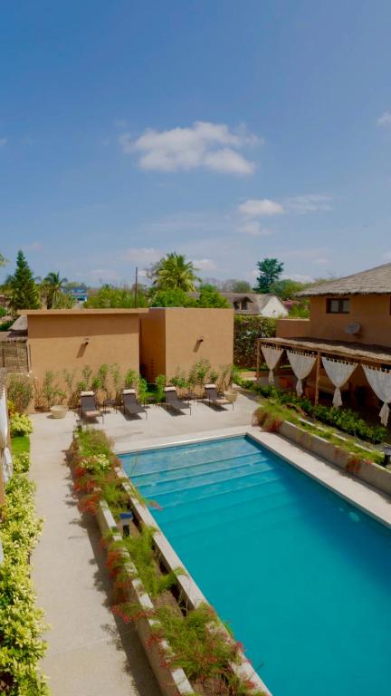 a swimming pool at a resort with lounge chairs at Sama Lodge in Saly Portudal