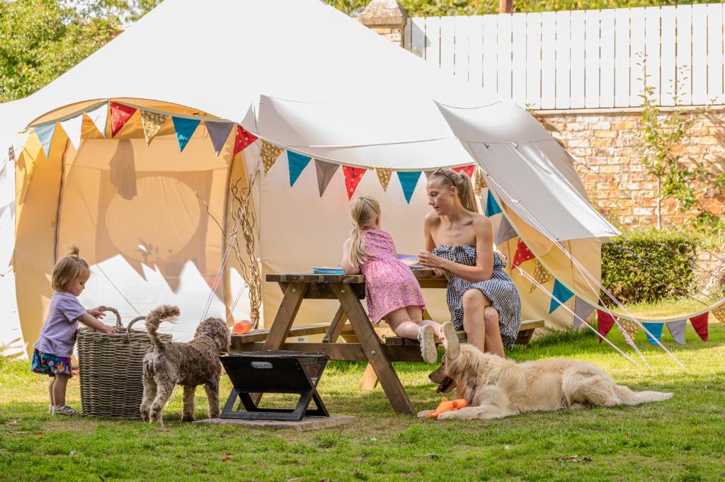 a woman and two children and two dogs in a tent at Aldwark Bridge Glamping - Lunar Tent in Aldwark