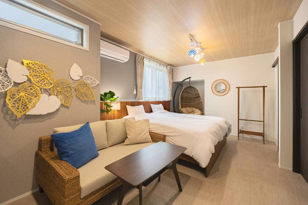 a bedroom with a bed and a couch and a table at suite Funabashi LAGOON1 #101 in Funabashi