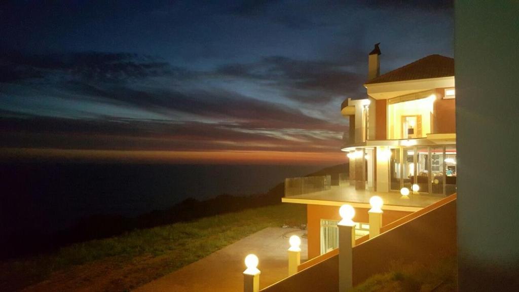 a building with lights on the side of it at night at Rothman's Sea View in Pacaltsdorp