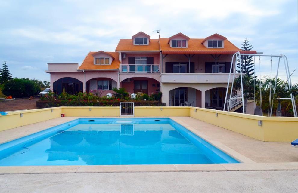 uma casa com piscina em frente a uma casa em Villa Victoria em Trou dʼ Eau Douce