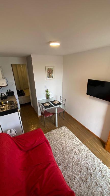 a living room with a red couch and a table at Solar do Braz Tiny House in Florianópolis