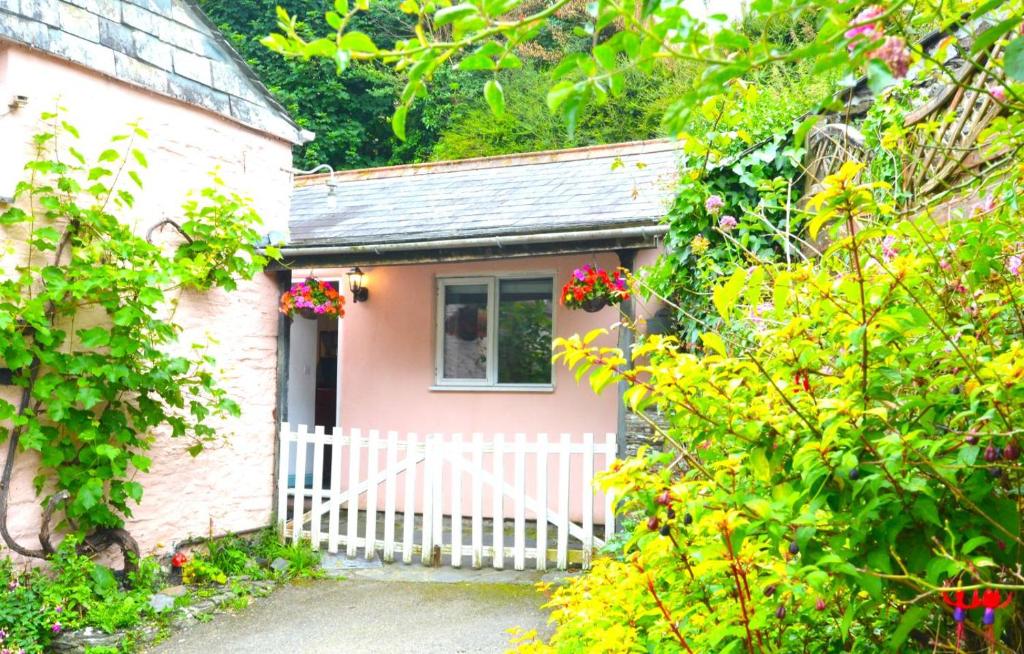 a small pink house with a white fence at 1 Bed in Wadebridge oc-p00223 in Little Petherick