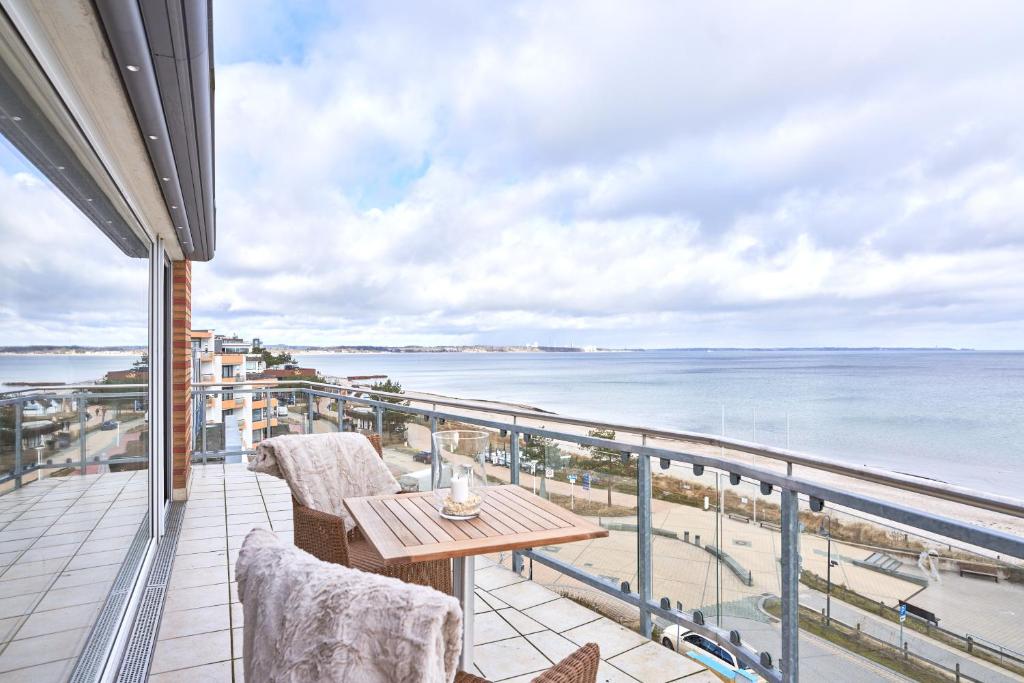 a balcony with a table and chairs and the ocean at Sea View Suite in Scharbeutz