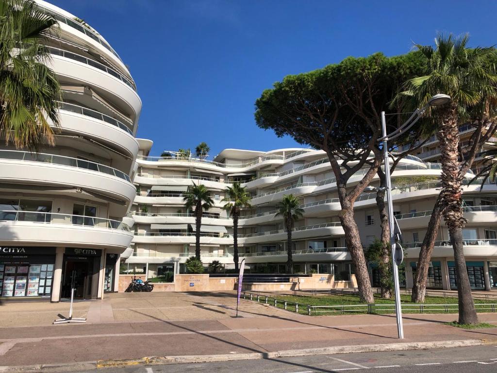 a large building with palm trees in front of it at T2 & Garage FRONT DE MER résidence de Standing in Fréjus