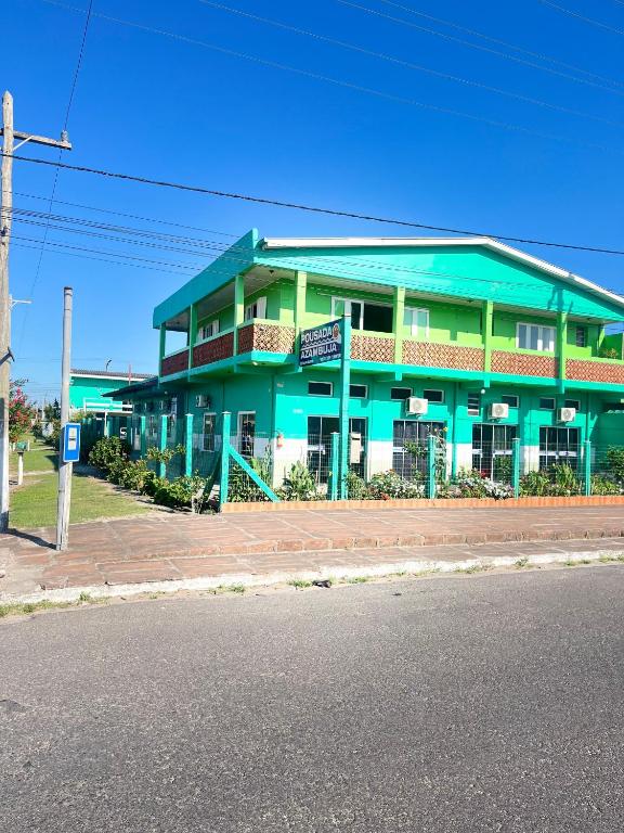 a green building on the side of a street at Pousada Azambuja in Cidreira