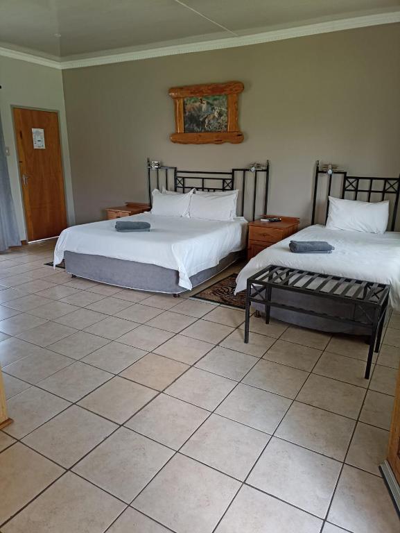 a bedroom with two beds and a tiled floor at Ingwe Guest lodge in Vanderbijlpark