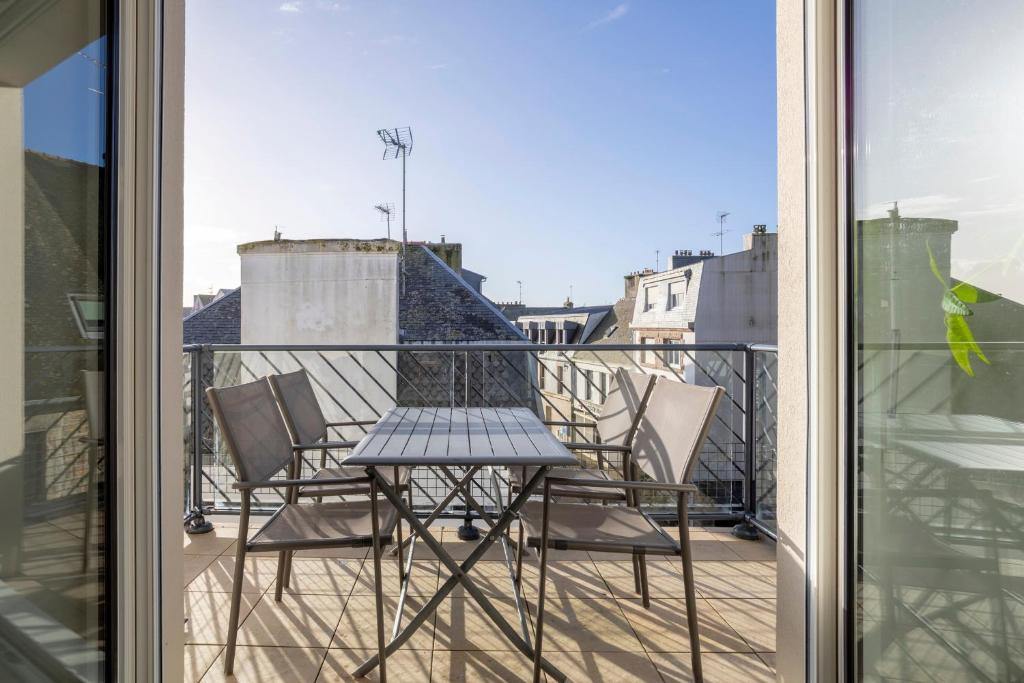 a table and chairs on a balcony with a view at Urania - Escale centre Concarneau in Concarneau
