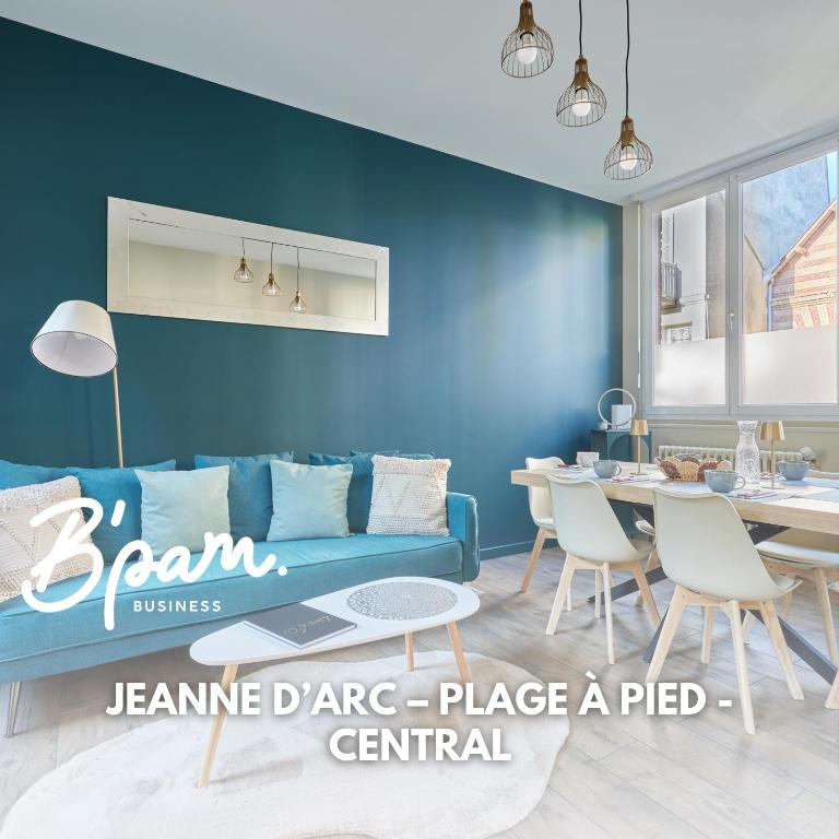 a living room with a blue couch and a table at Jeanne d'Arc - Plage à pied - Central in Villerville