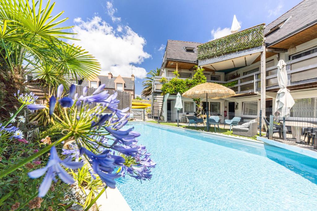 a swimming pool with blue flowers next to a building at Ouest Découvertes in Crozon