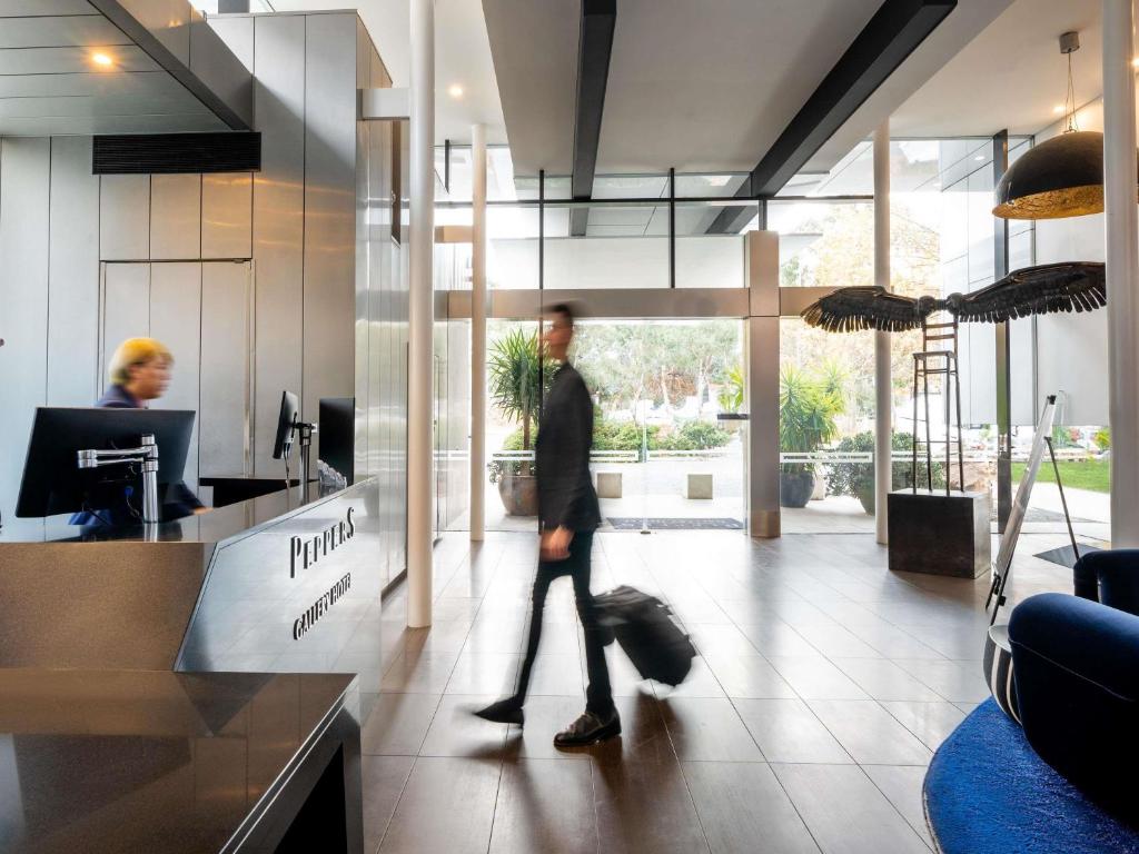 a man walking in an office with a suitcase at Peppers Gallery Hotel in Canberra