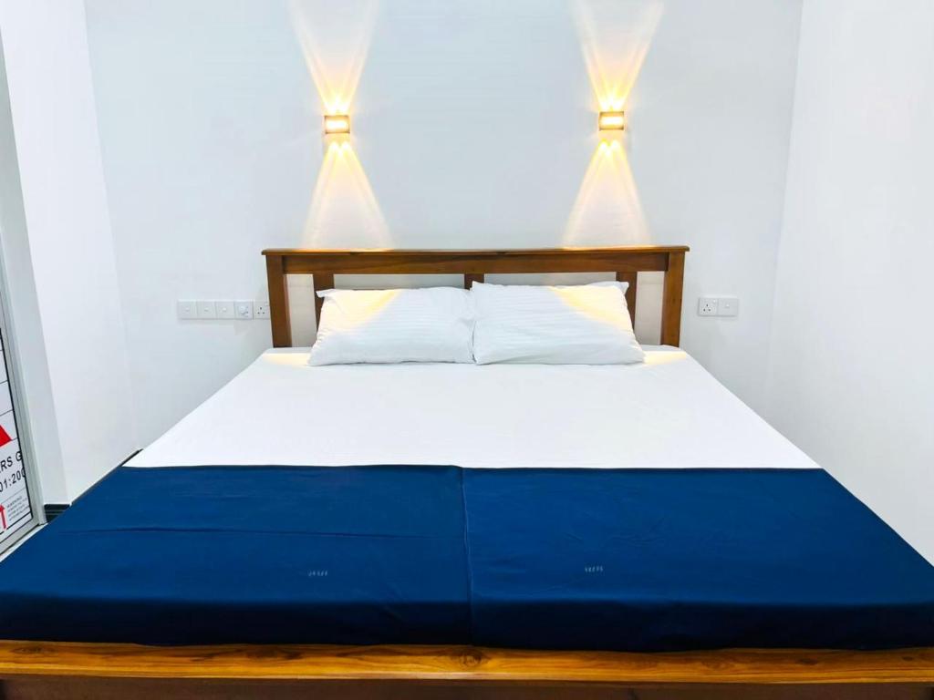 a bedroom with a blue and white bed with two lights at Bluebell Guest House in Unawatuna