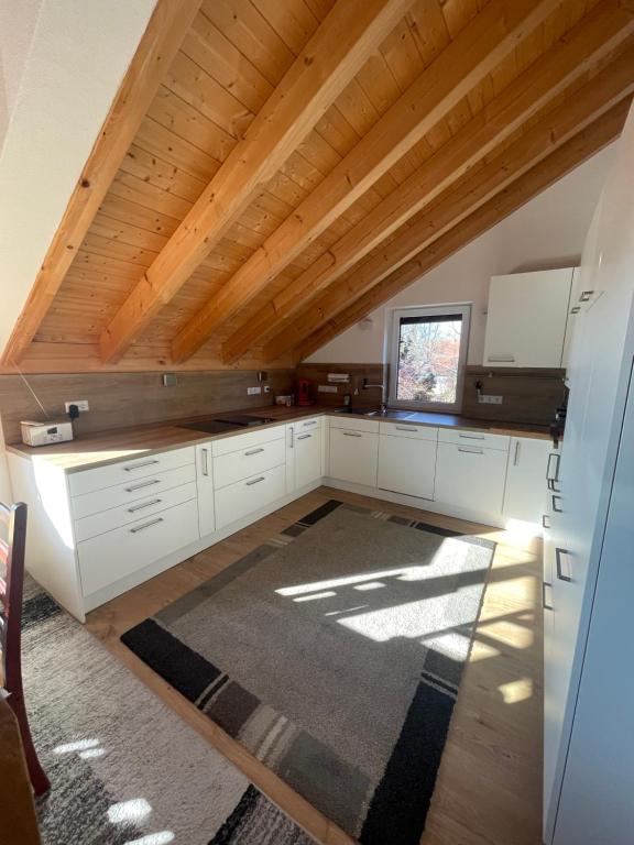 a kitchen with white cabinets and a wooden ceiling at Bordinghouse Arndt in Memmingen