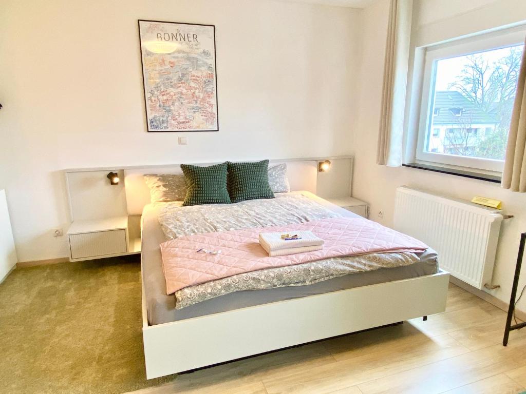 a bedroom with a white bed with a pink blanket at Ruhige Gästezimmer in Bonn mit Gemeinschaftsbad & Küche in Bonn