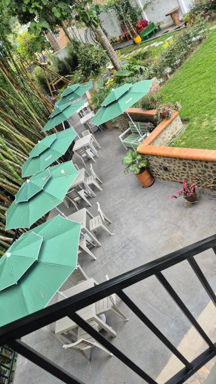 a group of chairs and umbrellas on a patio at Hotel Casa Bambu in Calima