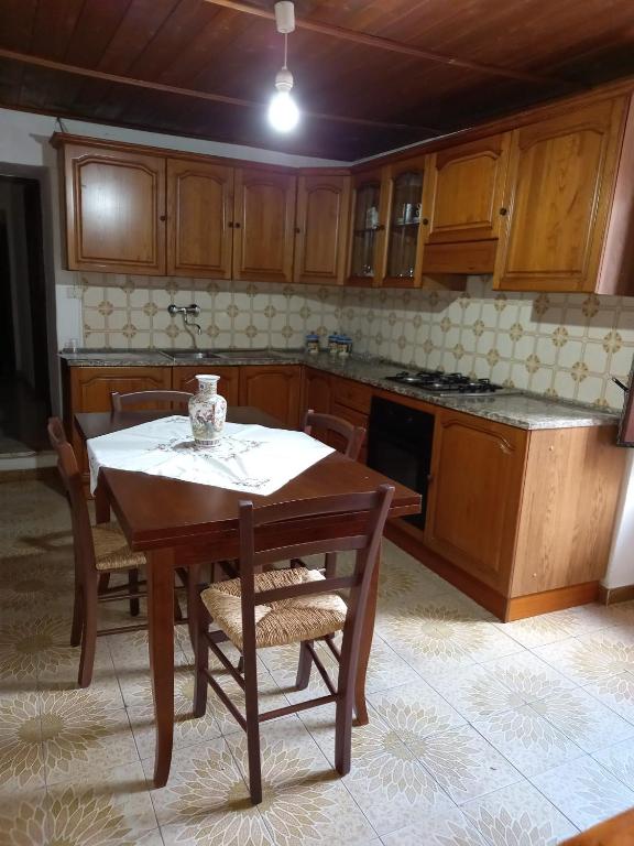 a kitchen with a wooden table and a table and chairs at Casa Roberta in Martis