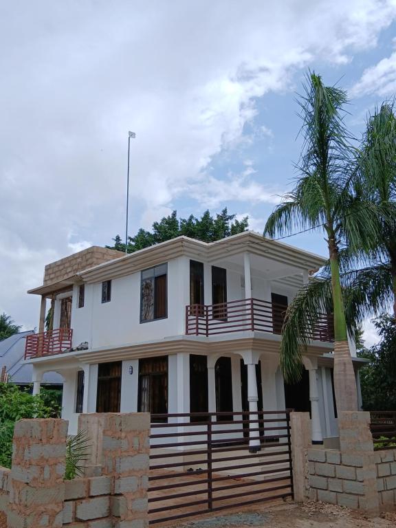 a house with a palm tree in front of it at Hidalgo Home Apartment's in Moshi