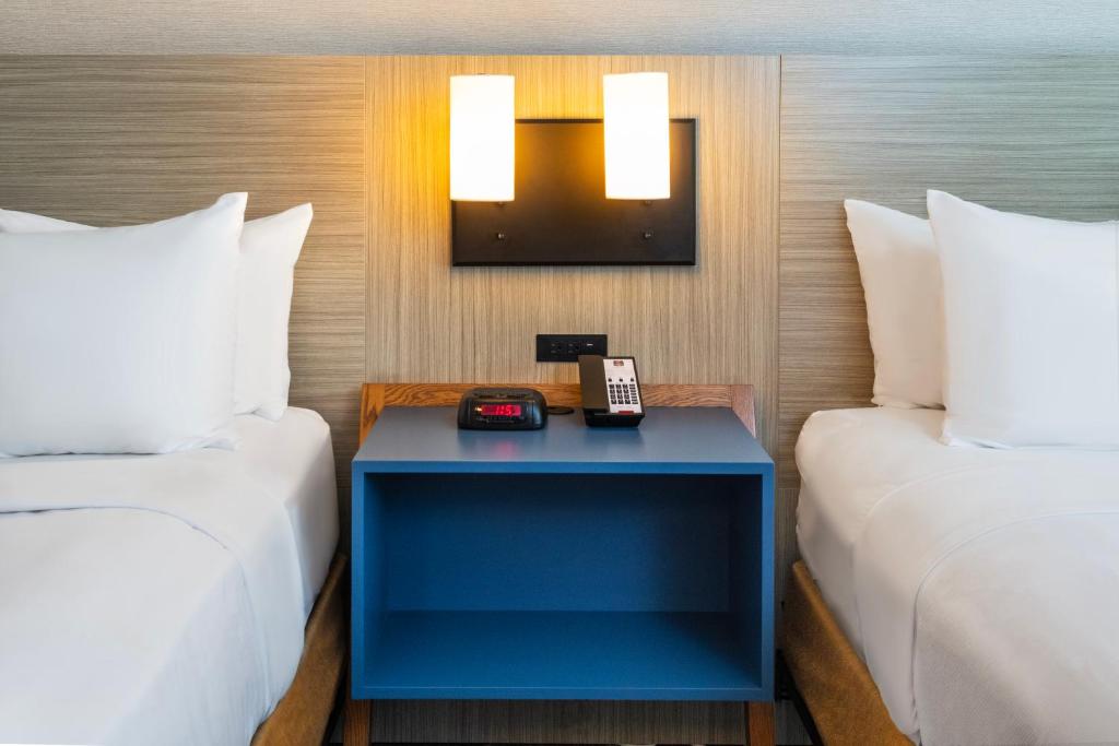 a hotel room with two beds and a blue table with a phone at Comfort Inn Montreal - Laval - Highway 15 in Laval