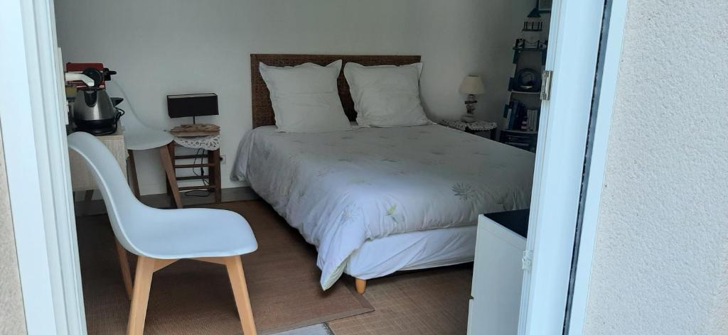 a bedroom with a bed and a chair in it at Chambre d hôtes in Crach