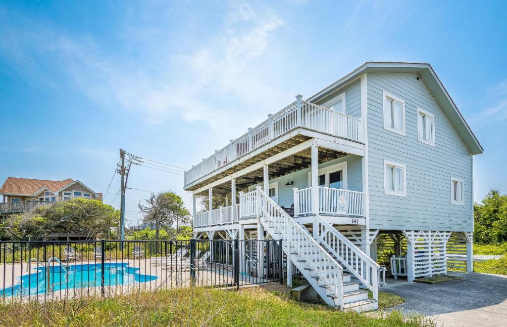 a blue house with white stairs in front of it at Arcadia - Duck, Caffey's Inlet, Ocean Views, 50 Yards to Beach, Pool, Pets OK, Cul-de-sac Location in Duck