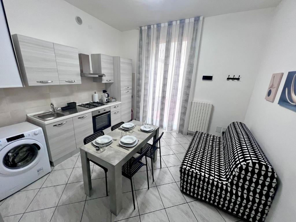 a kitchen with a table and a washing machine at A due passi dal Centro Intero appartamento con AC e WiFi in Forlì