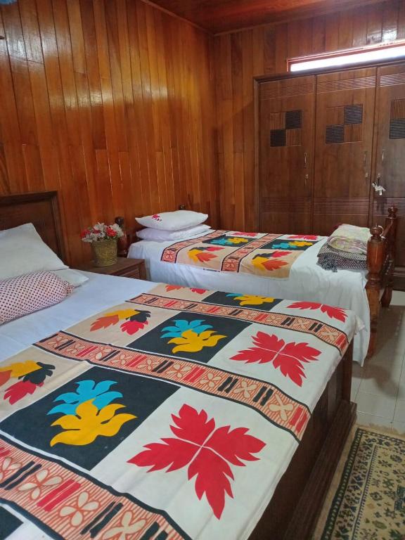 a group of three beds in a room at Antique Villa in Gampola