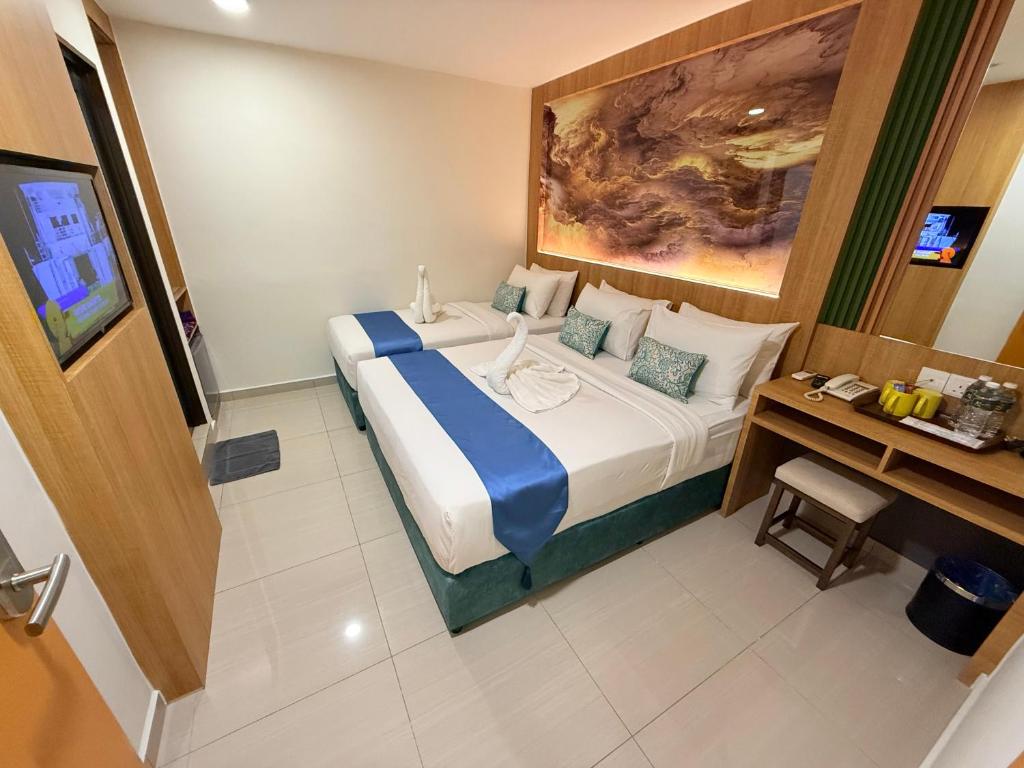 A double room with a built-in desk, stool, beverage supplies, mini-fridge and television.