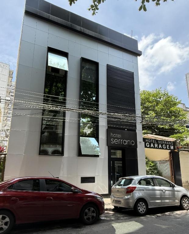 two cars parked in front of a building at Hotel Serrano in Rio de Janeiro