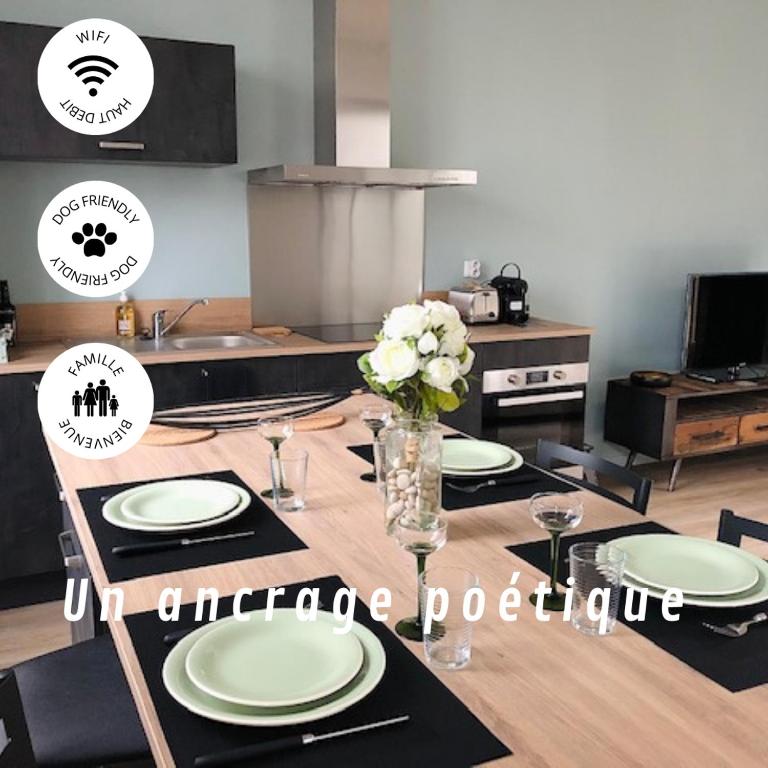 a dining room table with plates and a vase of flowers at Maison Gabriel Appartement LUNE in Abbeville