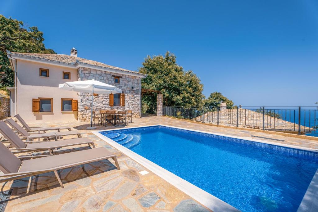 a villa with a swimming pool and a house at Pelion Villa Serenity View in Pouríon