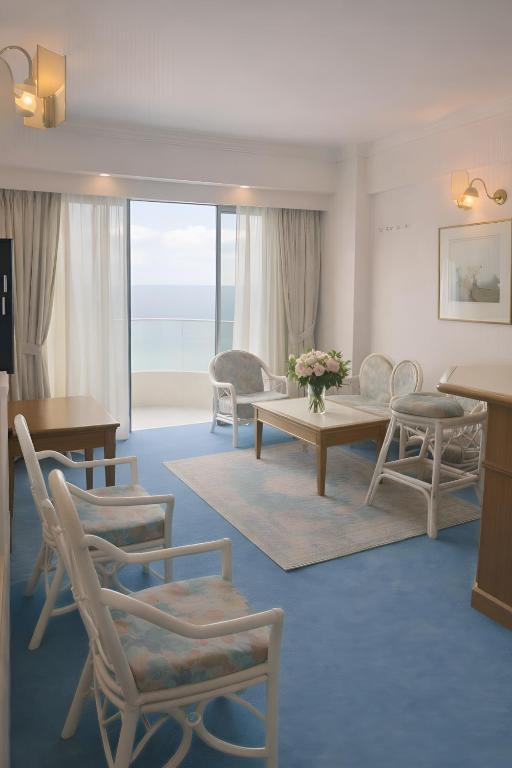 a living room with chairs and a table with a view at 1BR Seaview Condo with Balcony at Riviera Bay Resort, Melaka in Malacca