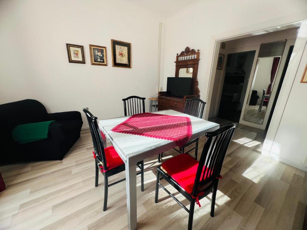 a living room with a table and chairs with a red cloth on it at Suite Semeria 38 - Sanremo in Sanremo