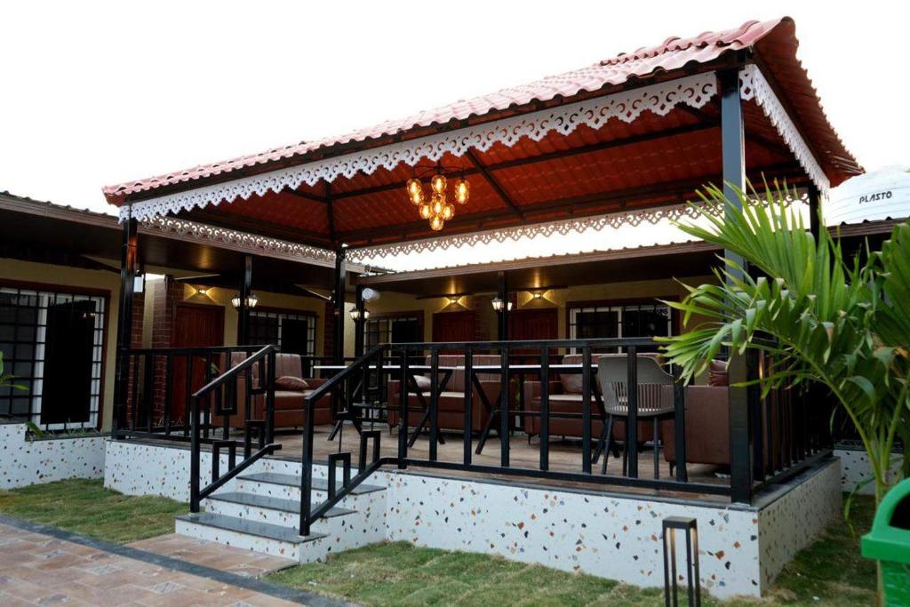 a patio with a deck with chairs and tables at Manish Inn Resort in Daulatābād